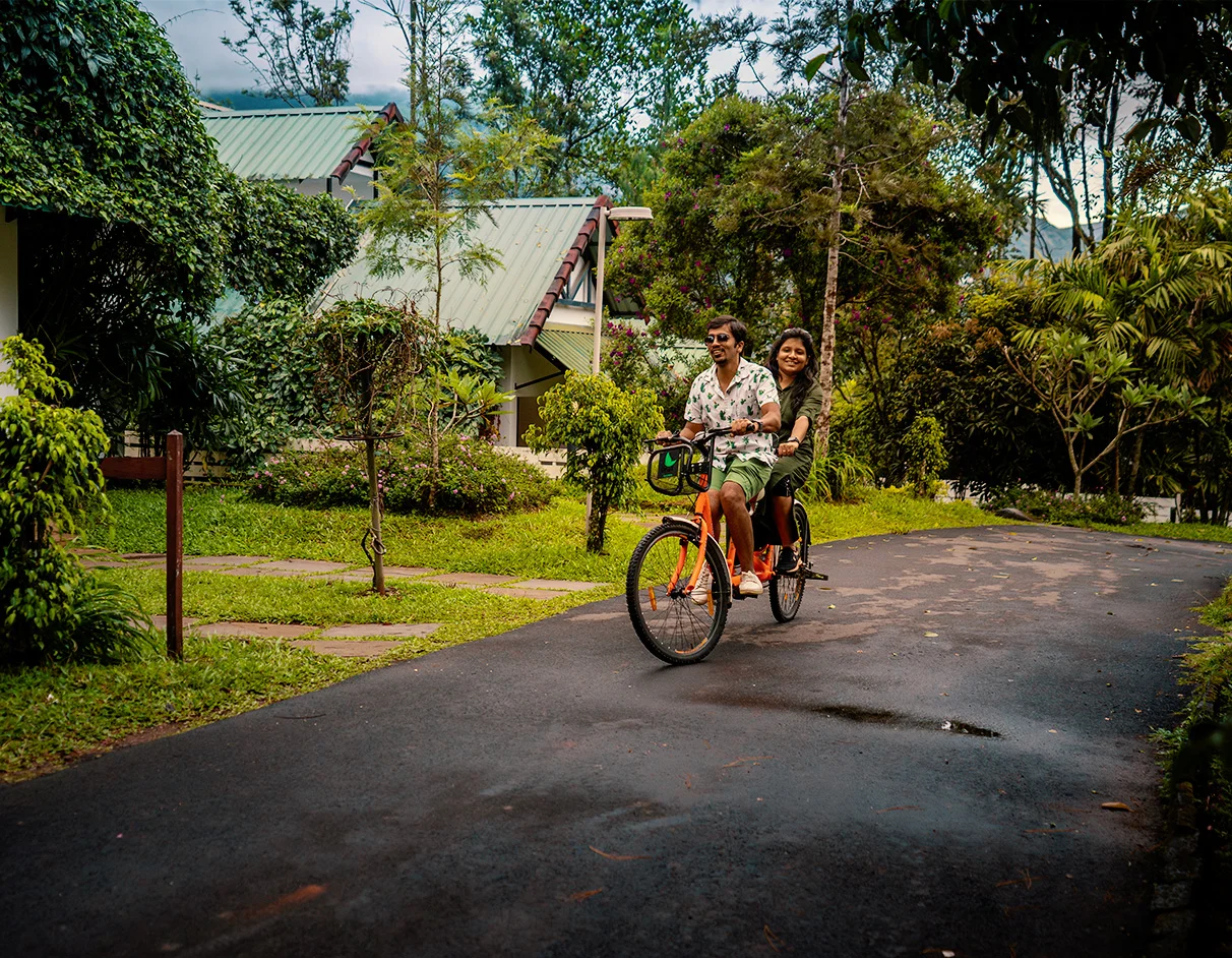 Family enjoying a leisurely bike ride outdoors during a peaceful family stay in Munnar at Misty Fern resort